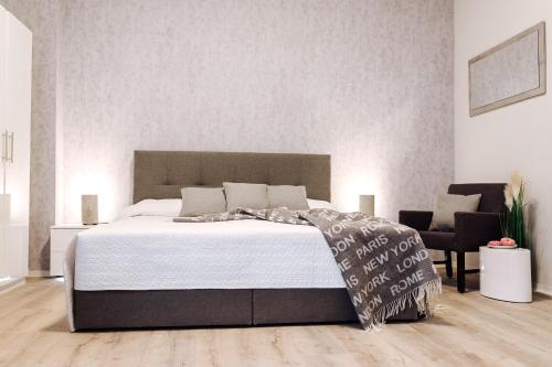 - une chambre avec un grand lit et une chaise dans l'établissement Apartment an der Altstadt (#5), à Hameln