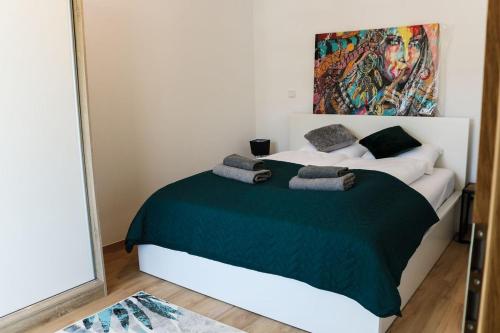 a bedroom with a large bed with a green blanket at Willa VITA Muszyna - rodzinne apartamenty blisko natury i atrakcji - 15min pieszo do centrum - 15min autem do stoku in Muszyna