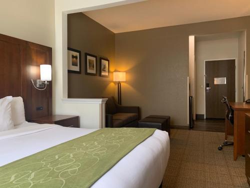 una camera d'albergo con letto, sedia e scrivania di Comfort Suites Peoria I-74 a Peoria