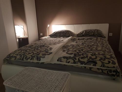a bed with a black and white comforter and pillows at Vikendica Nika in Rab