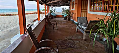 een restaurant met stoelen en tafels op het strand bij Pousada Dalva in Galinhos