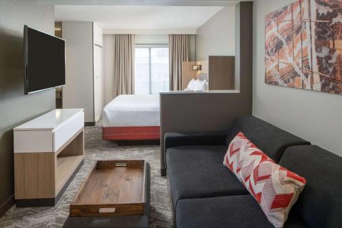 een woonkamer met een bank en een bed bij Sonesta Select Nashville Airport Suites in Nashville