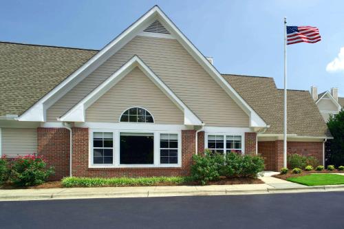 une maison arborant un drapeau américain devant elle dans l'établissement Sonesta ES Suites Raleigh Cary, à Cary