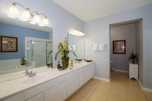 a bathroom with two sinks and a large mirror at Vista Cay Luxury 4 bedroom condo in Orlando