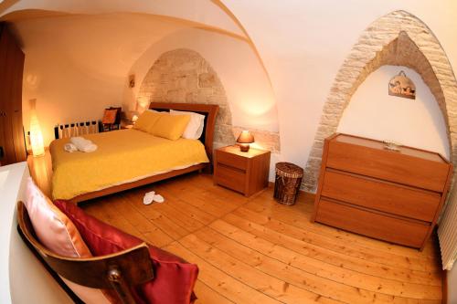 une chambre avec un lit et un parquet dans l'établissement Il Frantoio 1937, à Terlizzi