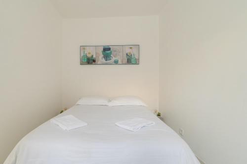 Una cama blanca en una habitación con una foto en la pared en L'Arpajonnais 6 Cosy Hyper Centre Terrasse N20, en Arpajon