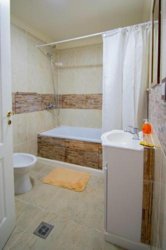 a bathroom with a tub and a toilet and a sink at ABC DEPARTAMENTOS in Ushuaia