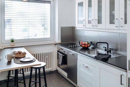 a kitchen with white cabinets and a sink and a table at Apartment in Hameln # Rom in Hameln
