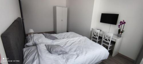 a bedroom with a bed with white sheets and pillows at Noclegi Szymrych in Chełmsko Śląskie