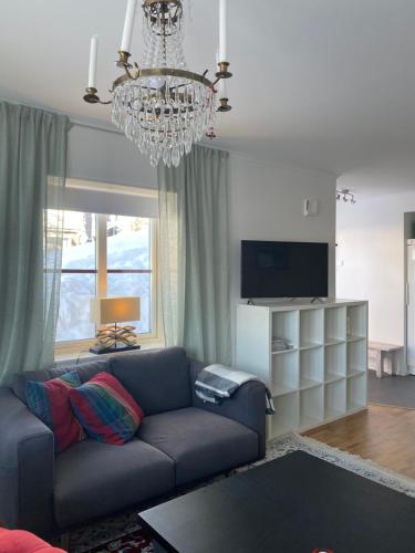 a living room with a blue couch and a chandelier at VARIJLYAN in Sälen
