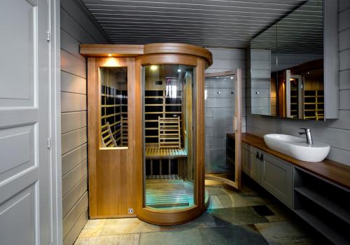 a bathroom with a wooden shower and a sink at Mosetertoppen Panorama anneks 3B in Hafjell