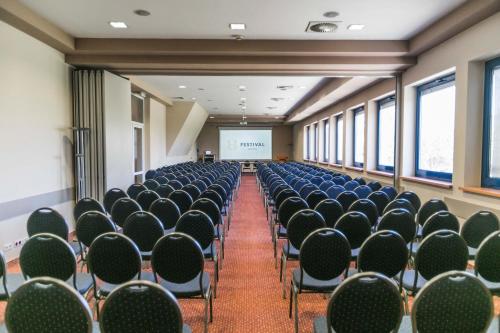 an empty room with chairs and a projector screen at Hotel Festival in Opole