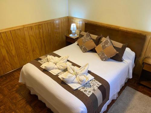 a hotel room with a bed with towels on it at Hostal America en Puerto Natales in Puerto Natales