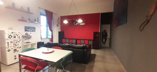 a living room with a table and a red wall at Casa baja in Bacoli