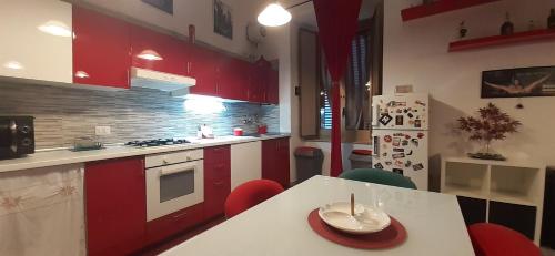 uma cozinha com armários vermelhos e uma mesa com um prato em Casa baja em Bacoli