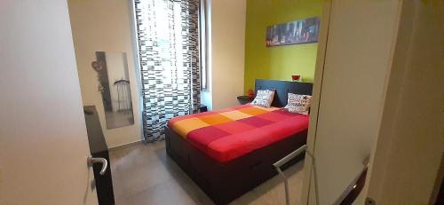 a bedroom with a bed with a colorful blanket at Casa baja in Bacoli