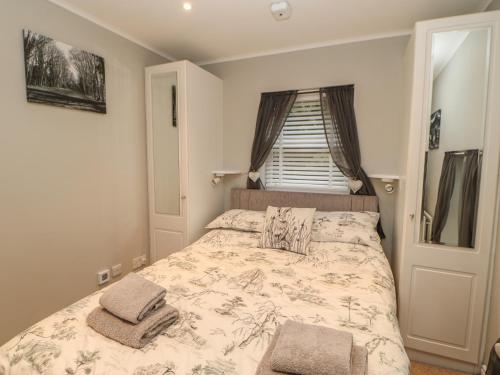 a bedroom with a bed with two pillows on it at Honeysuckle Cottage in Richmond