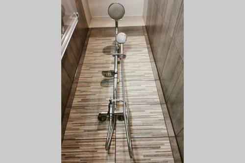 um banheiro com dois chuveiros em piso de madeira em Little Big Red - Central Modern Studio na Cracóvia