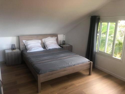 un letto in una camera da letto con una grande finestra di DUPLEX BOUGUAINVILLIER a Saint-Denis