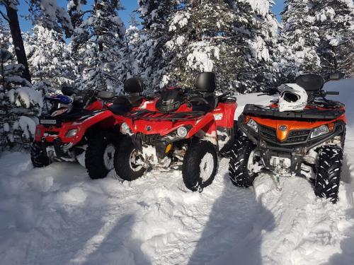 two atvs parked in the snow with snow covered trees at Mountain House Tara Apartmani Nikolic in Kaludjerske Bare