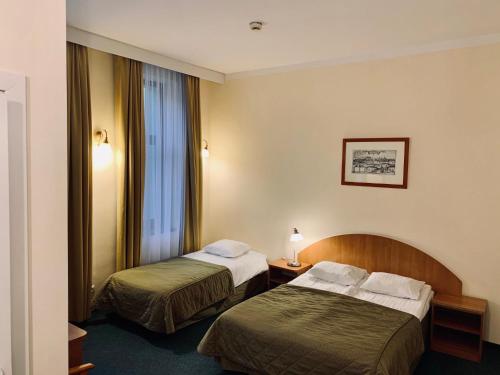 pokój hotelowy z dwoma łóżkami i oknem w obiekcie Matejko Hotel w Krakowie