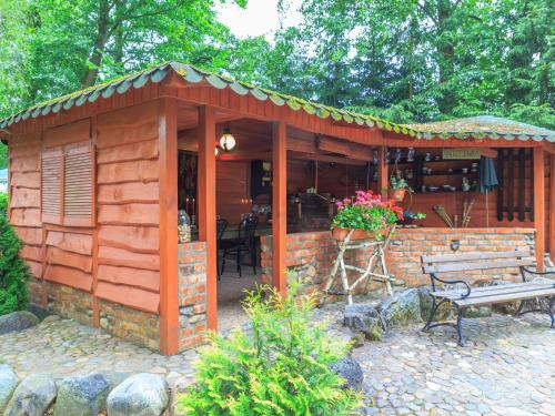 a wooden shed with a bench in a garden at Lovely Apartment in Rusko with Pool Garden in Darłowo