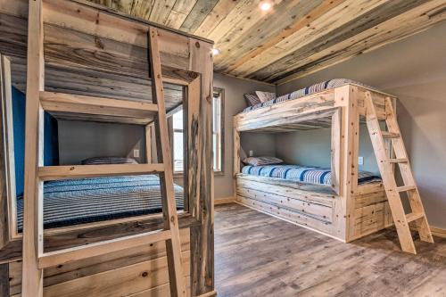 two bunk beds in a room with wooden ceilings at Upscale Riverfront Home with Beach and Fire Pit! in Glenwood