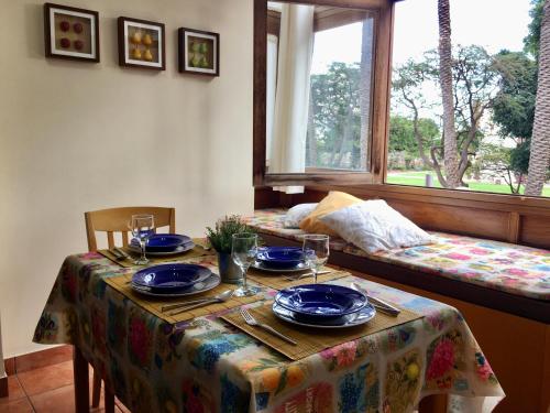 a table with plates and glasses on it with a window at LOS FRAILES I in San Sebastián de la Gomera
