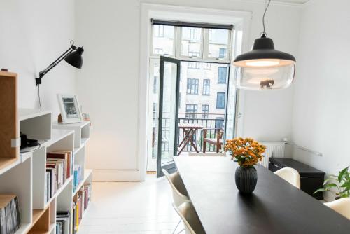 a room with a table with a vase of flowers on it at ApartmentInCopenhagen Apartment 1357 in Copenhagen