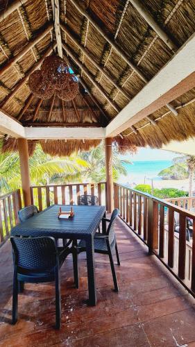 玛哈威Hotel Machos Mahahual的门廊上摆放着桌椅的露台