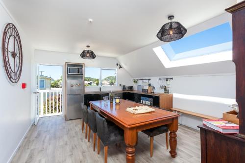 a kitchen with a wooden table in a room at Sunset Sands Holiday Accomodation in Waihi Beach