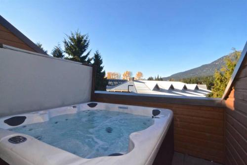 a jacuzzi tub on a balcony with a view at Hearthstone Lodge loft, Village centre, Private Hot tub, sleeps 6 in Whistler