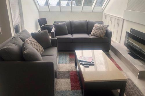 a living room with a couch and a table at Hearthstone Lodge loft, Village centre, Private Hot tub, sleeps 6 in Whistler