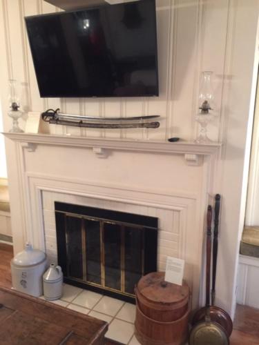 a fireplace with a flat screen tv on top of it at Willard Richards Inn in Nauvoo