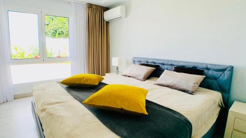a bedroom with a large bed with yellow pillows at Casa Solaris at Anfi Beach with Private Terrace, Pool & Netflix in Arguineguín