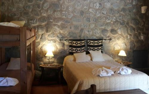 a bedroom with a bed and two tables with lamps at Posada de campo Maia in Merlo