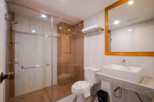 a bathroom with a toilet and a sink and a shower at Shagwell Mansions in Pattaya Central
