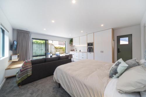 a bedroom with a large bed and a couch at Remarkable Studio in convenient Frankton in Frankton Wharf