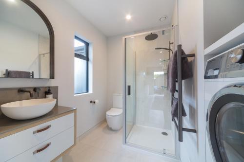 a bathroom with a sink and a washing machine at Remarkable Studio in convenient Frankton in Frankton Wharf