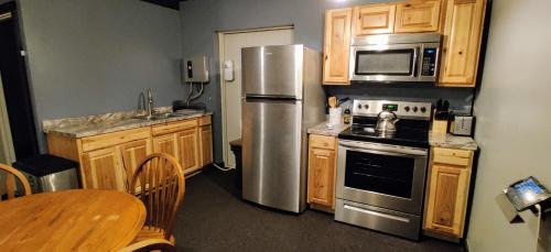 a kitchen with wooden cabinets and a stainless steel refrigerator at Becker's Private Studio 2 Queen Beds, 1 Futon with a Great Back Yard! in Auburn