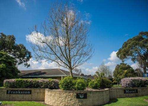 una casa con un árbol en un patio en Frankston Motel, en Frankston
