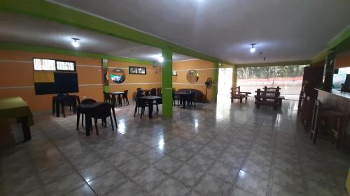 una habitación con mesas y sillas y un escenario. en Hostel Peter Pan en Puerto Iguazú