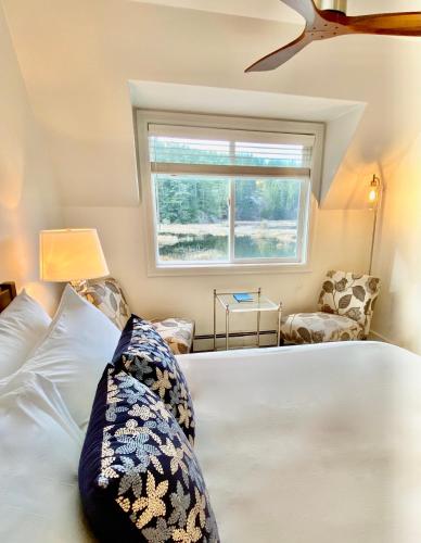 a bedroom with a white bed and a window at Otter's Pond Bed and Breakfast in Eastsound