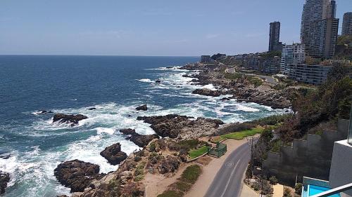 a road next to the ocean next to a beach at Exclusivo Departamento Con Con Primera Linea in Concón