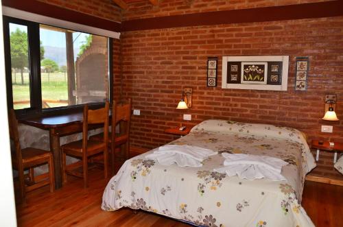 a bedroom with a bed and a desk and a table at Pachanavira Cabañas & Suites in Nono