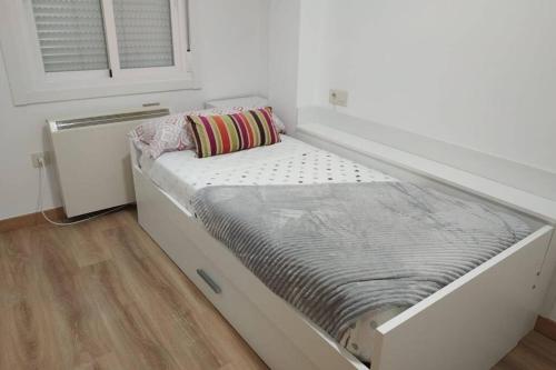 1 cama blanca grande en una habitación con ventana en nuevo centrico y 15 min cerca de aguas termales en Ourense