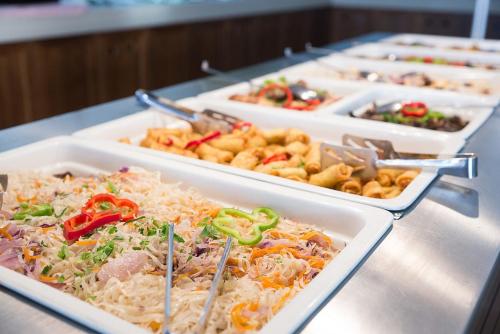 a buffet with several trays of food on a table at Comfort Inn Tulip Heights in Bathinda