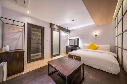 a bedroom with a large bed and a table at Chuncheon Bom Stay in Chuncheon