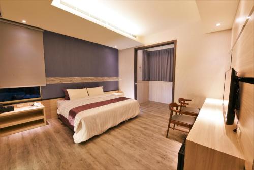 pokój hotelowy z łóżkiem i telewizorem w obiekcie Yu Kun Tien Hotel w mieście Shalu
