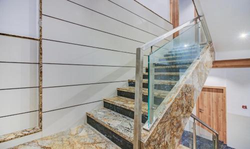 a staircase in a house with a glass railing at Hotel Aarush Inn in Navi Mumbai